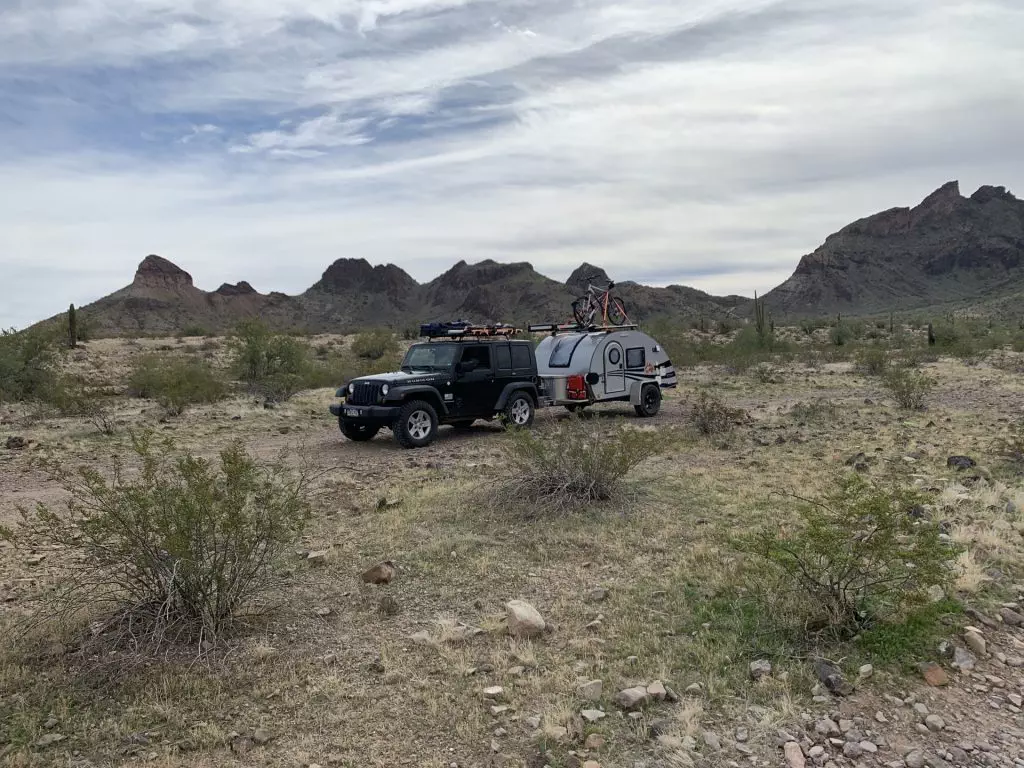 A jeep and teardrop trailer parked in the desert near Signal Mountain.